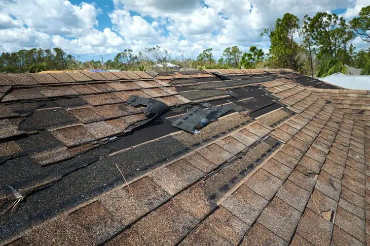 Damaged roof with missing shingles after storm